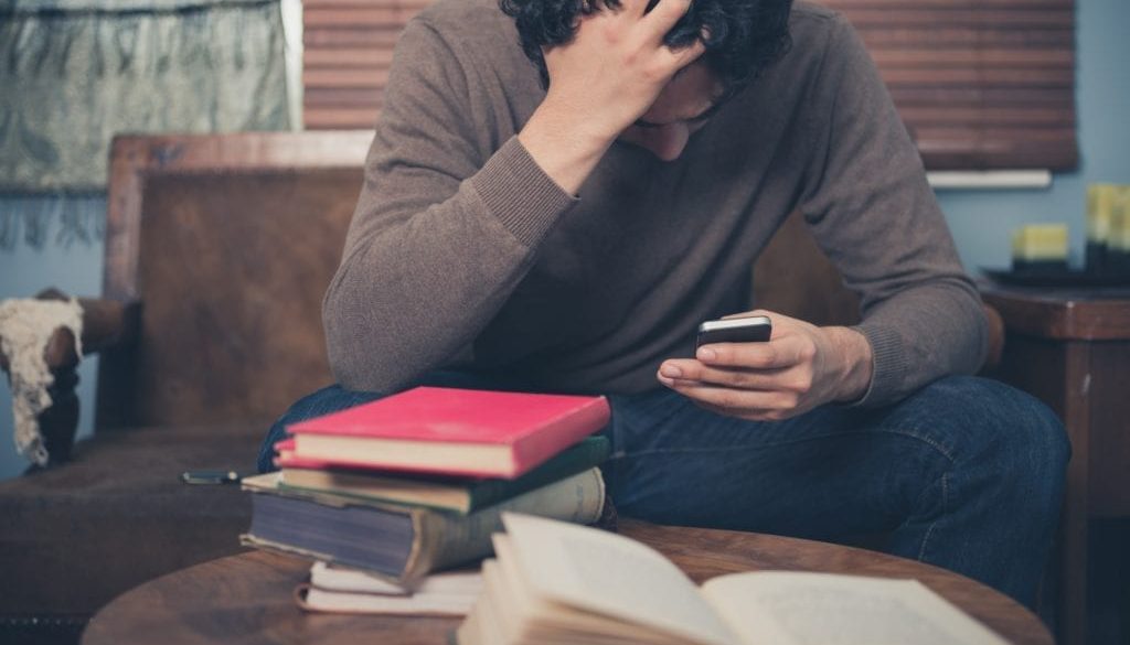 distressed individual looking at his phone